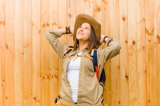 Jeune exploratrice latine femme contre mur en bois