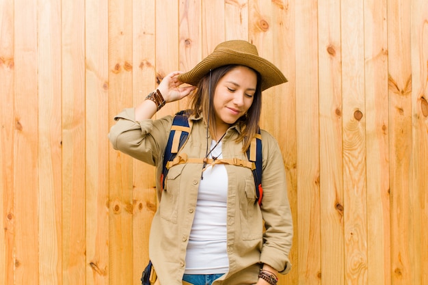 Jeune exploratrice latine femme sur fond de mur en bois