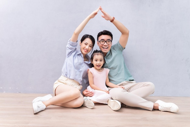 Jeune famille asiatique assise sur le sol