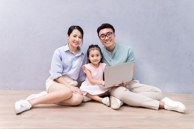 Jeune famille asiatique assise sur le sol