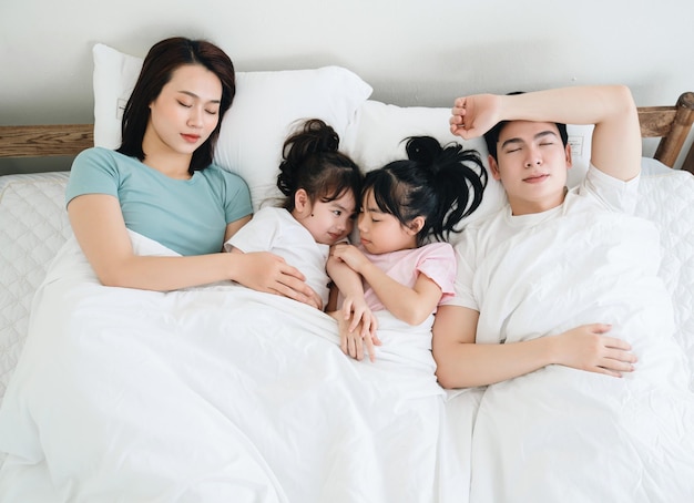 Jeune famille asiatique sur le lit