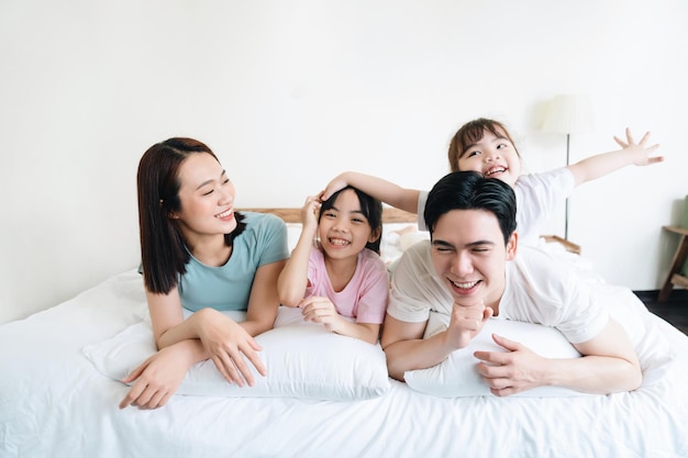 Jeune famille asiatique sur le lit