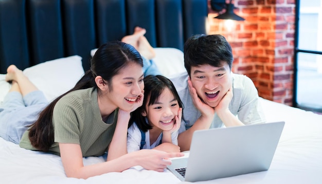 Jeune famille asiatique sur le lit