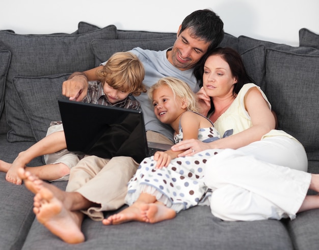 Jeune famille assise sur le canapé