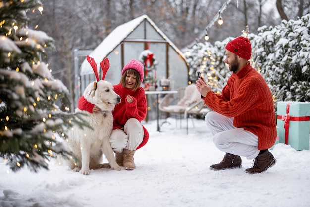 Une jeune famille avec un chien célèbre les vacances d'hiver