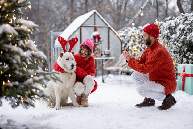 Une jeune famille avec un chien célèbre les vacances d'hiver