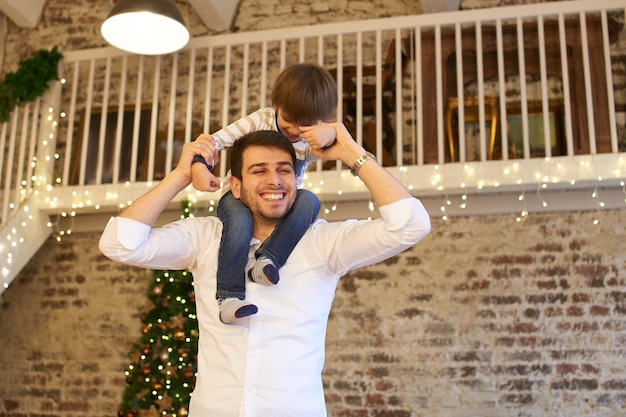 Une jeune famille dans l'appartement décoré pour Noël