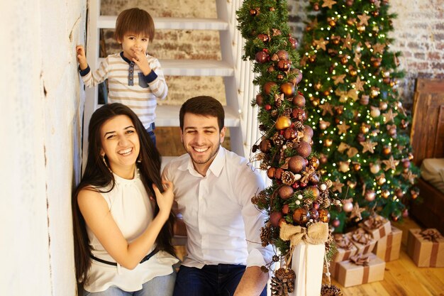 Une jeune famille dans l'appartement décoré pour Noël