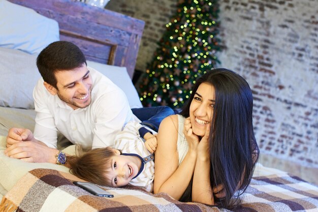 Une jeune famille dans l'appartement décoré pour Noël