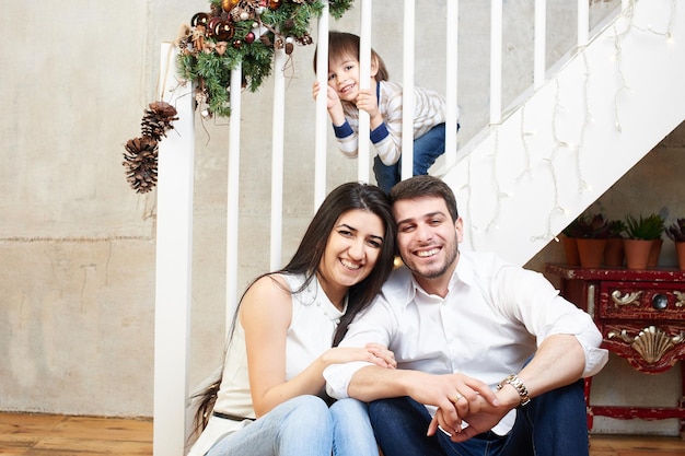 Une jeune famille dans l'appartement décoré pour Noël