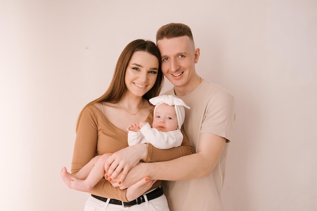 Photo jeune famille élégante photographiée avec un petit bébé magnifique la famille exprime l'amour et la crainte les uns envers les autres concept de famille et de parentalité