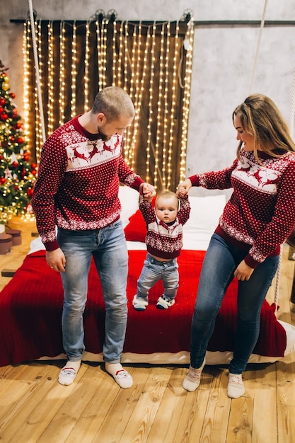 Jeune famille avec un enfant à l'intérieur, ambiance de Noël,