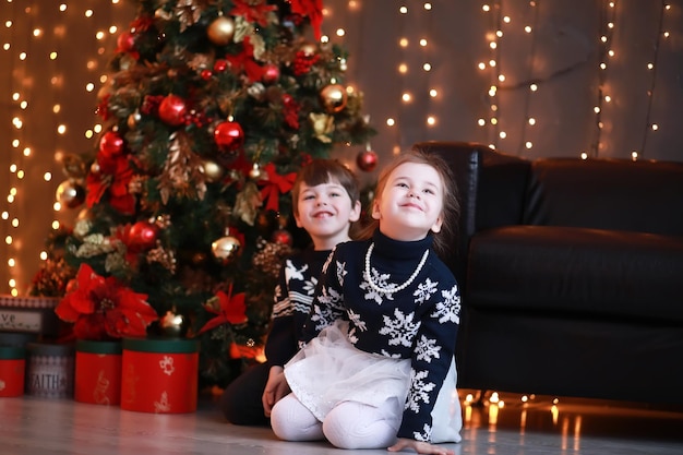 Une jeune famille avec des enfants décore la maison pour les vacances du Nouvel An en attendant la nouvelle année