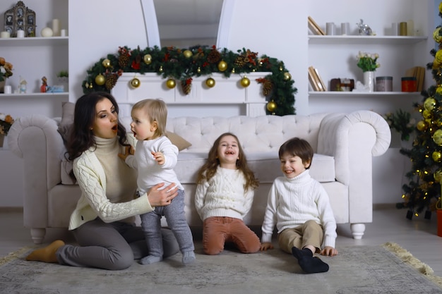 Une jeune famille avec enfants décore la maison pour les vacances. Réveillon de Nouvel an. En attendant la nouvelle année.