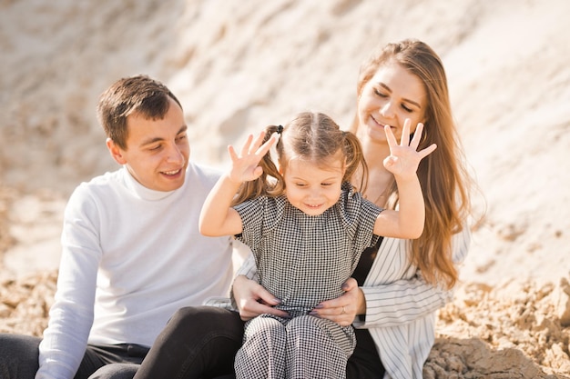 Une jeune famille est assise parmi les montagnes sablonneuses 3359