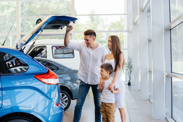 Une jeune famille heureuse chez le concessionnaire automobile