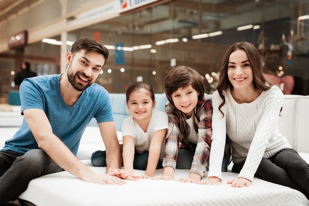 Jeune famille heureuse choisir un matelas ensemble