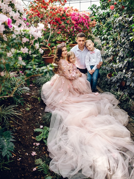 Jeune famille heureuse dans un jardin de printemps en fleurs