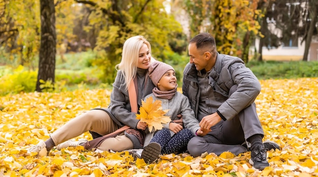 Jeune famille heureuse en marchant dans le parc en automne.