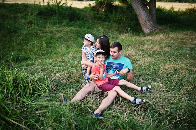 Jeune famille heureuse : mère, père, fils de deux enfants sur la nature s'amusant.