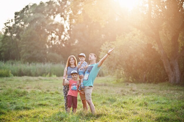 Jeune famille heureuse : mère, père, fils de deux enfants sur la nature s'amusant.