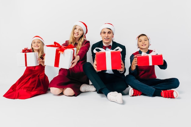 Jeune famille heureuse Noël avec les enfants en chapeaux de Père Noël