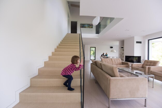 une jeune famille heureuse avec une petite fille s'amuse dans le salon moderne de leur villa de luxe