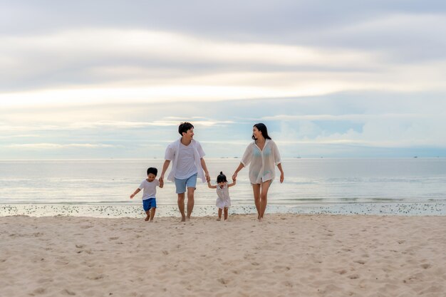 Jeune famille heureuse sur la plage de sable