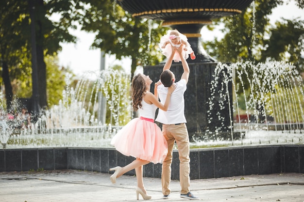 Jeune famille heureuse près de la fontaine