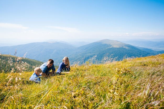 La jeune famille heureuse rassemble des baies dans les montagnes