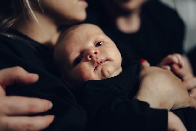 Jeune famille heureuse à la recherche de portrait de famille avec bébé