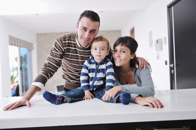 une jeune famille heureuse s'amuse et se détend dans une nouvelle maison avec des meubles lumineux