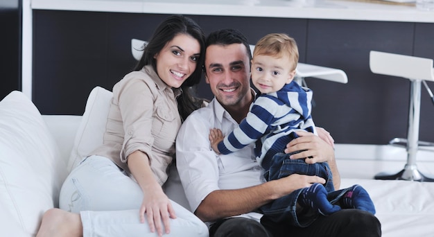 une jeune famille heureuse s'amuse et se détend dans une nouvelle maison avec des meubles lumineux
