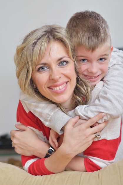 une jeune famille heureuse s'amuse avec ses enfants dans un salon moderne à l'intérieur