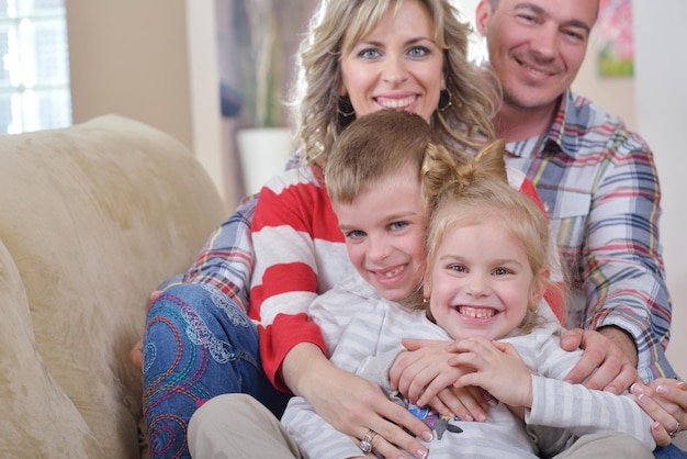 une jeune famille heureuse s'amuse avec ses enfants dans un salon moderne à l'intérieur