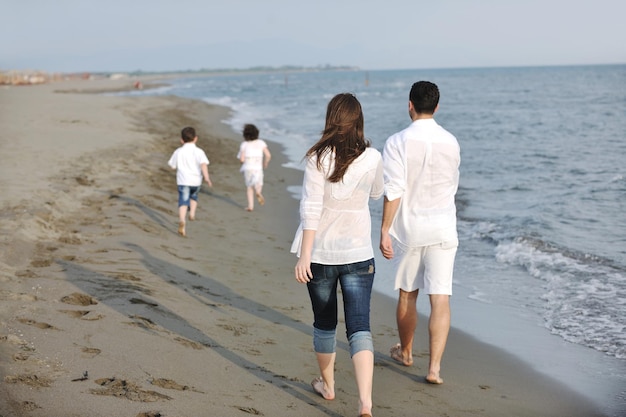 jeune famille heureuse s'amuser et vivre une vie saine sur la plage