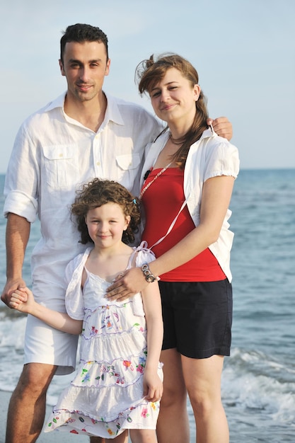 jeune famille heureuse s'amuser et vivre une vie saine sur la plage