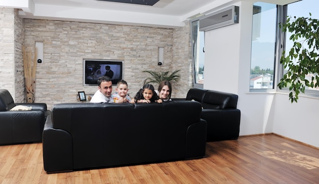 Une jeune famille heureuse se détend et s'amuse dans une maison moderne à l'intérieur