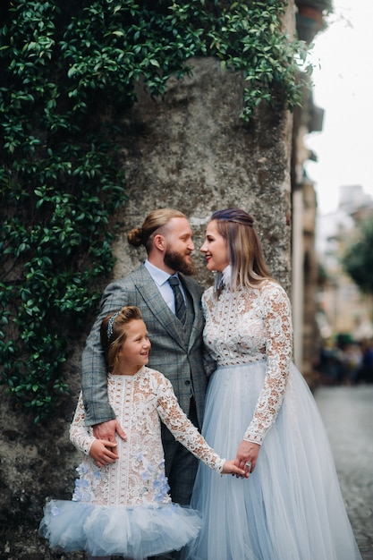 Une jeune famille heureuse se promène dans la vieille ville de Sirmione en Italie.Famille élégante en Italie en promenade.