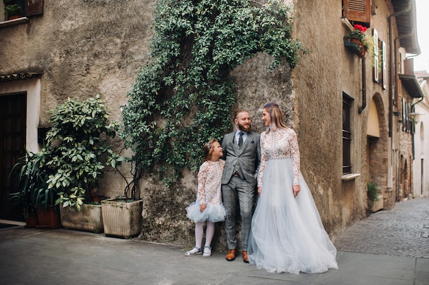 Une jeune famille heureuse se promène dans la vieille ville de Sirmione en Italie