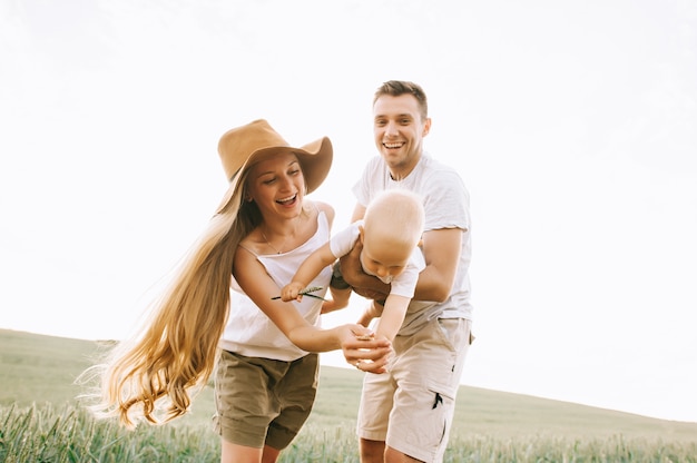 Une jeune famille heureuse sur le terrain s'amuse