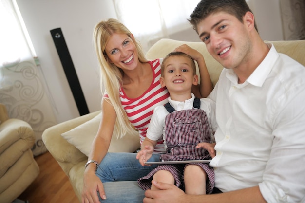 jeune famille heureuse utilisant une tablette à la maison moderne pour jouer à des jeux et à l'éducation