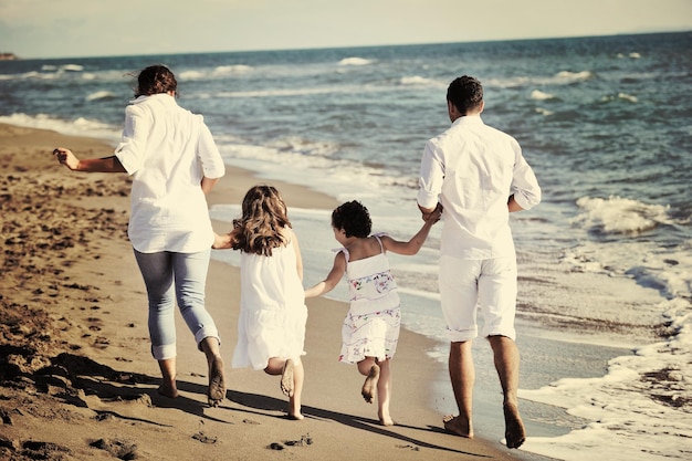 une jeune famille heureuse en vêtements blancs s'amuse en vacances sur une belle plage