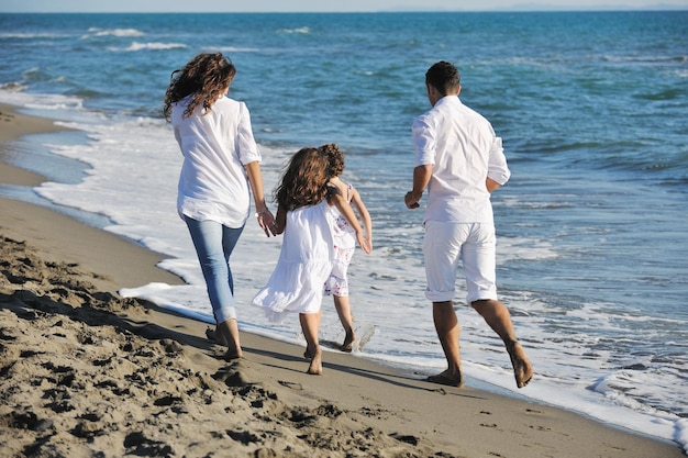 une jeune famille heureuse en vêtements blancs s'amuse en vacances sur une belle plage