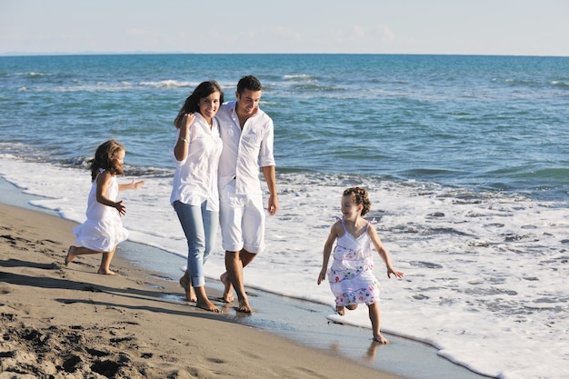 une jeune famille heureuse en vêtements blancs s'amuse en vacances sur une belle plage