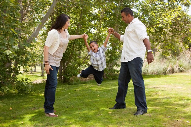 Une jeune famille hispanique s'amuse dans le parc