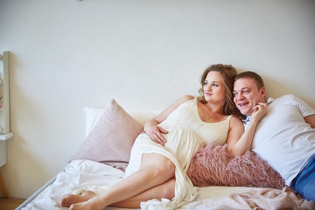 Jeune famille sur le lit dans la chambre