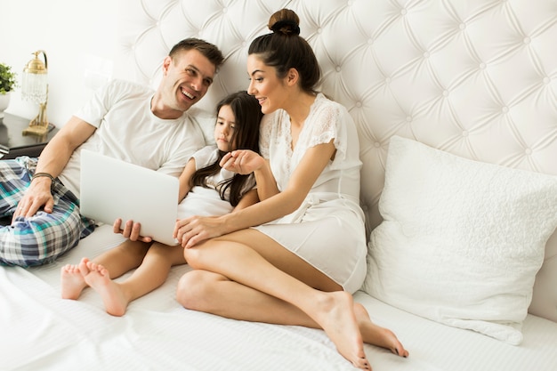 Jeune famille sur le lit