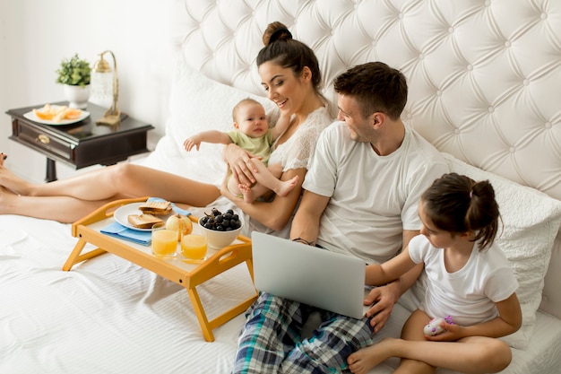 Jeune famille sur le lit