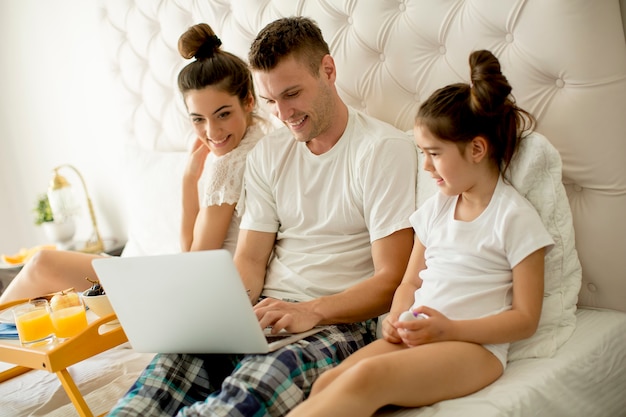 Jeune famille sur le lit